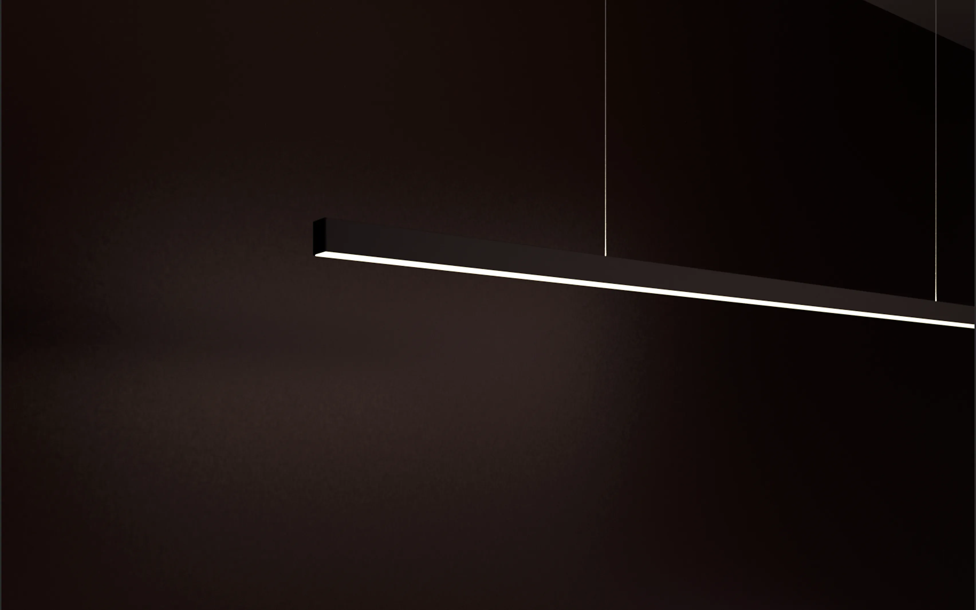 Schwarze Pendelleuchte GERA Quadra Swing im dunklen Raum.