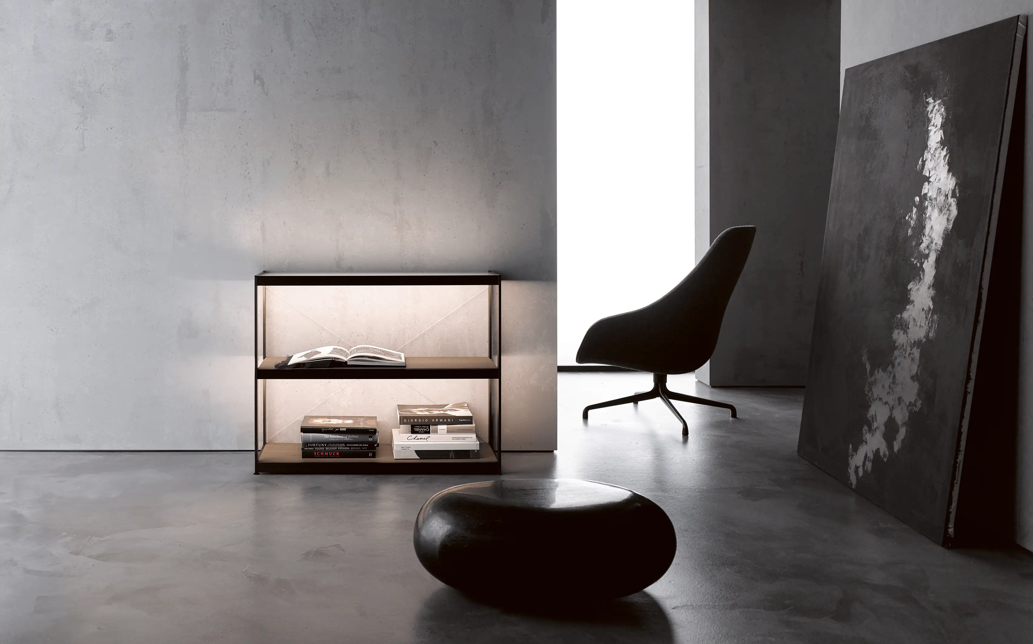 Minimalistisches Wohnzimmer mit beleuchtetem Sideboard GERA Item, schwarzem Sessel und abstraktem Gemälde, an der Wand lehnend.