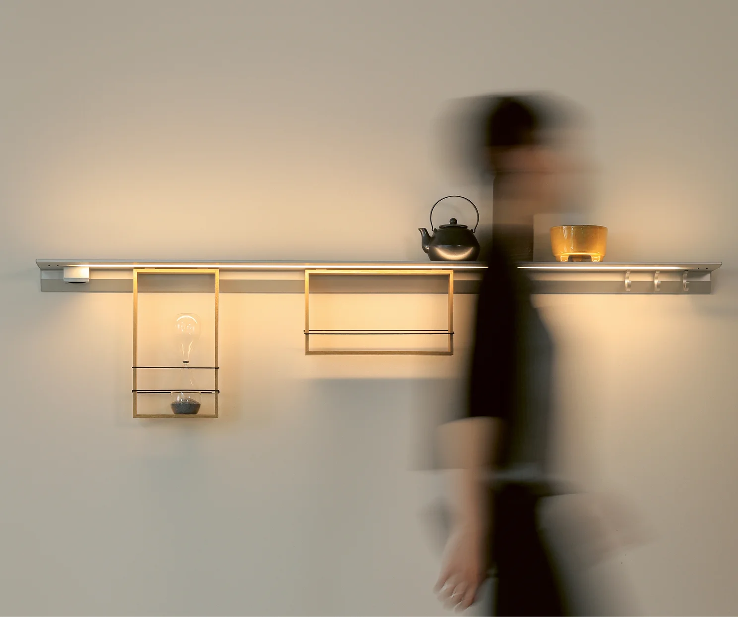 Eine dunkel gekleidete Frau läuft bewegungsunscharf an einem aluminiumfarbenen Lichtbord GERA Feature vorbei.