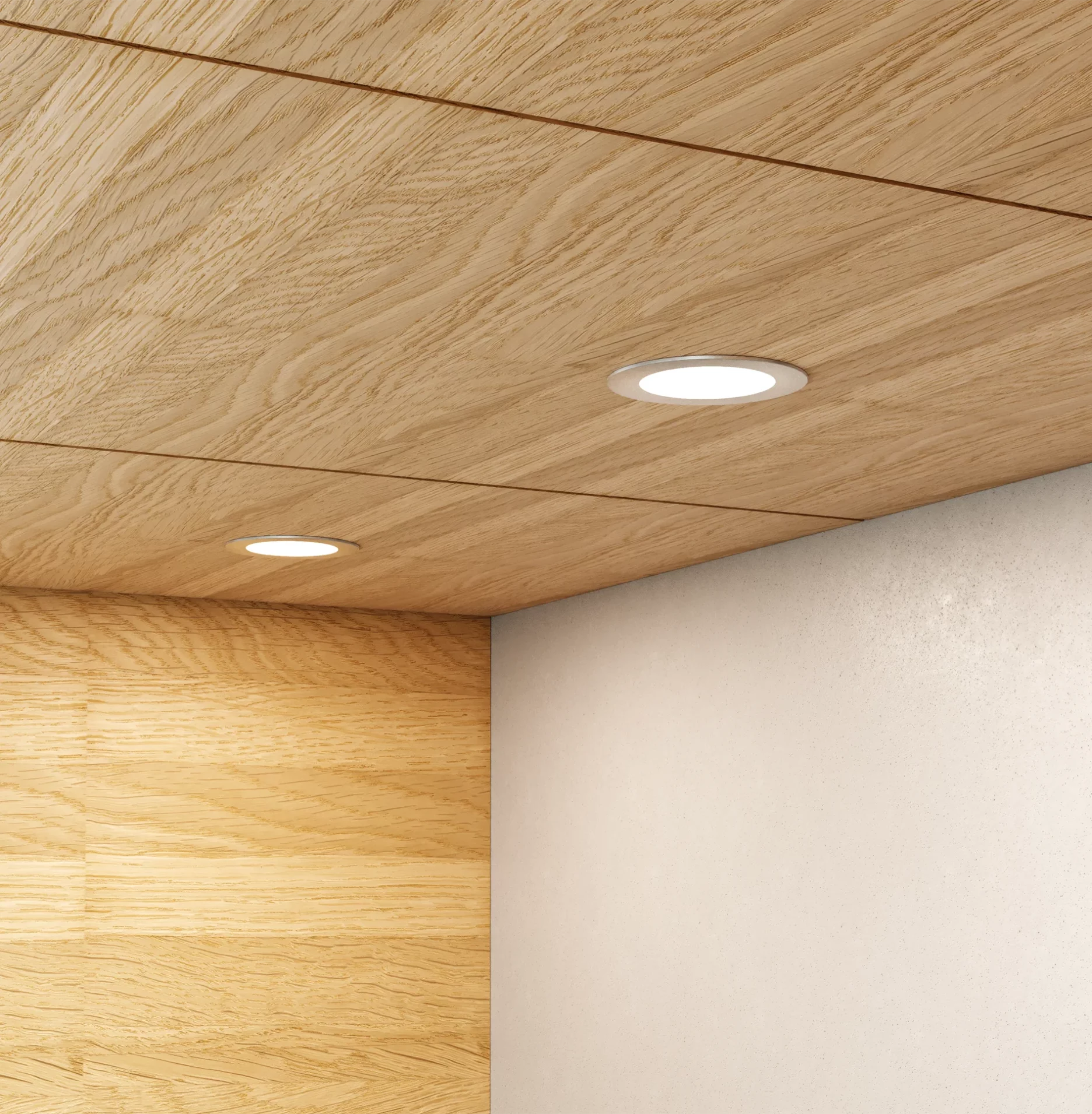 Nahaufnahme einer hölzernen Schrankunterseite mit zwei runden GERA Einbaustrahlern, die auf eine beigefarbene Wand darunter leuchten.