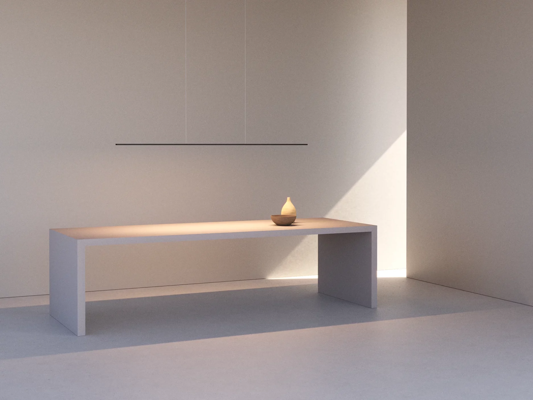 Minimalistischer Raum in Beige- und Grautönen mit einem schlichten, rechteckigen Tisch. Darauf stehen eine Schale und eine Vase, darüber hängt die Pendelleuchte GERA Horizon. Helles Sonnenlicht fällt von rechts ein, erzeugt diagonale Schatten und betont die Textur der Wände.