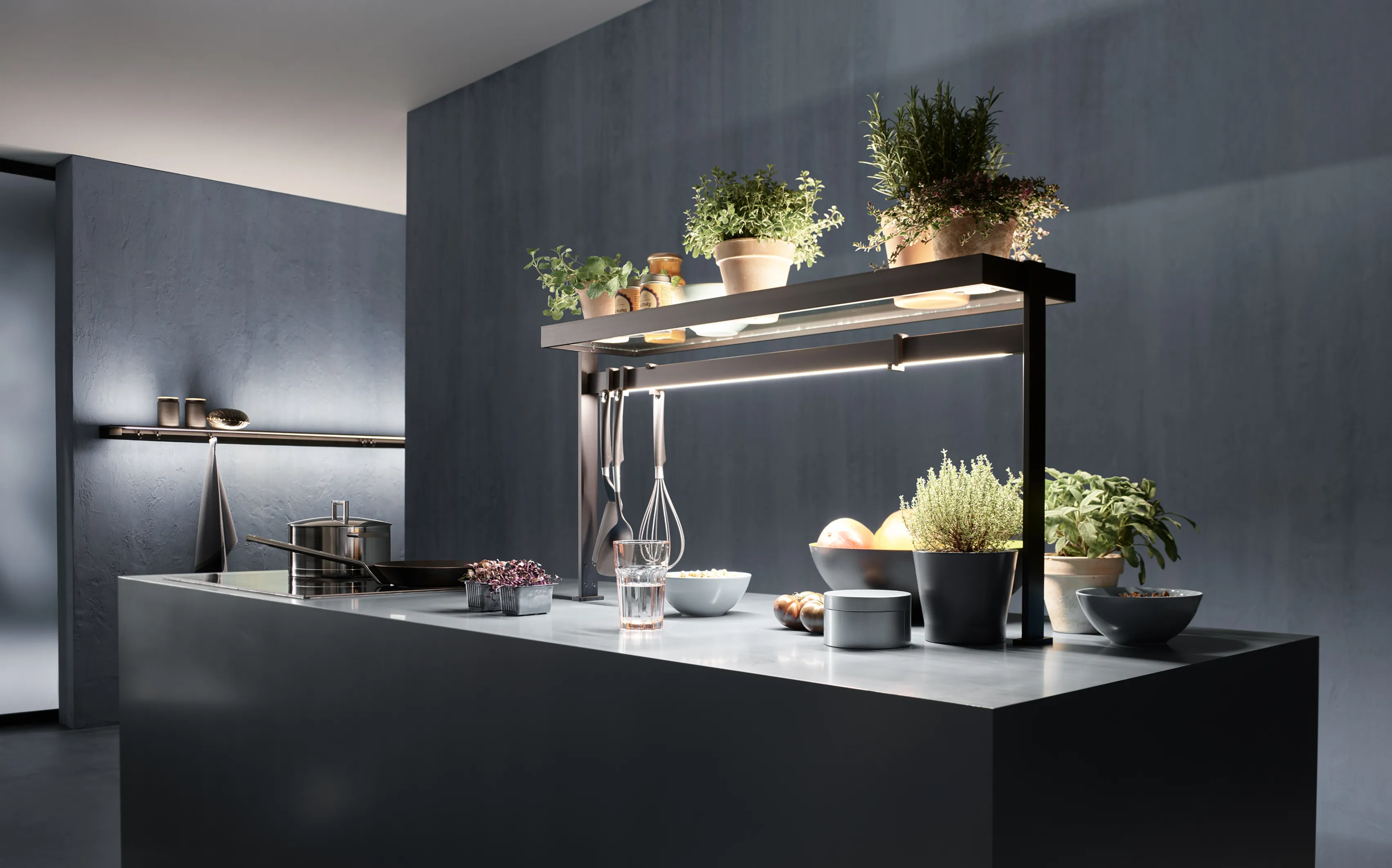 Moderne Kücheninsel mit Lichtbrücke GERA Lucina Up, Kochutensilien und frischem Gemüse.