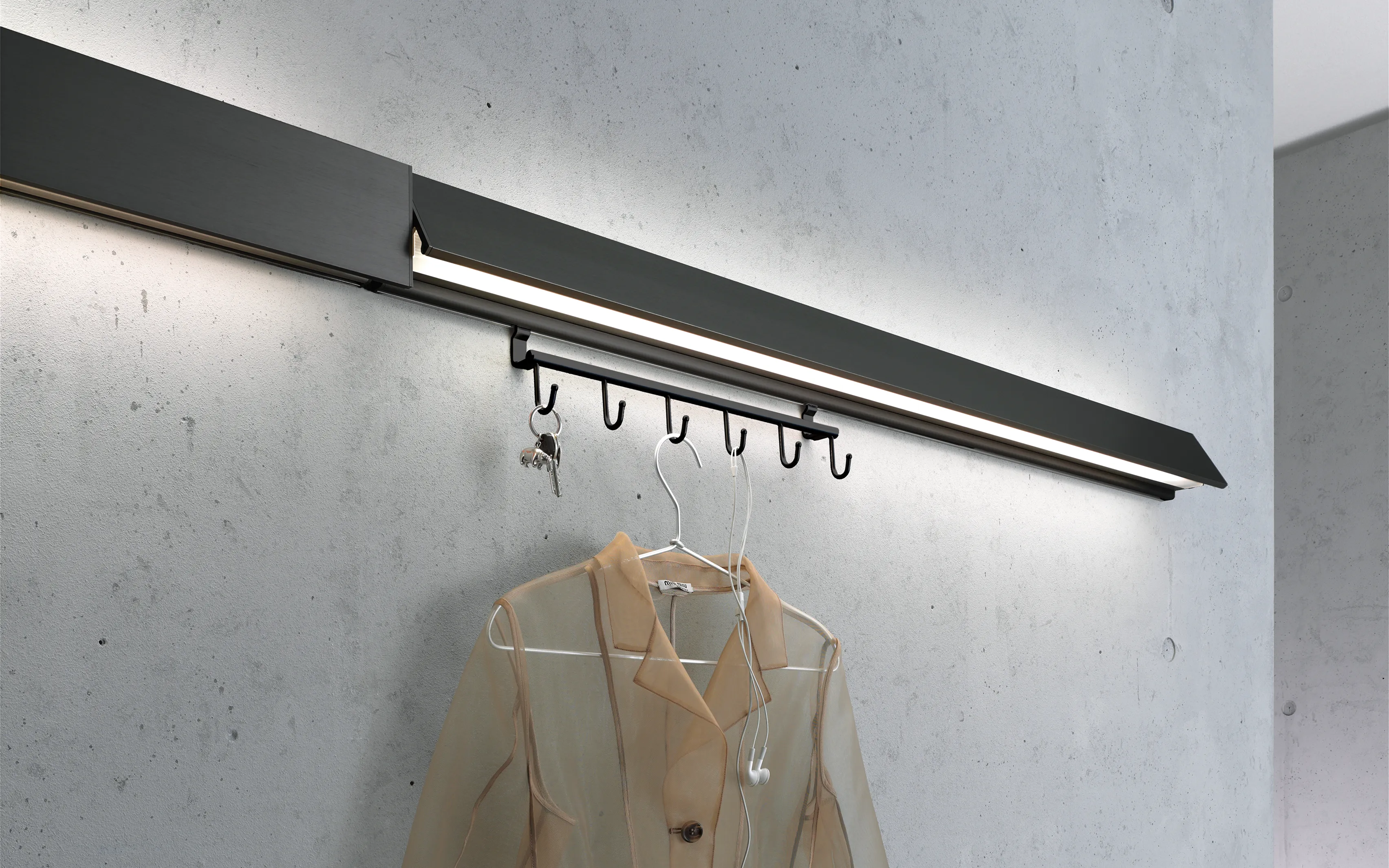 Schwarze Garderobenleuchte GERA Hook mit Hakenleiste an einer Sichtbetonwand.