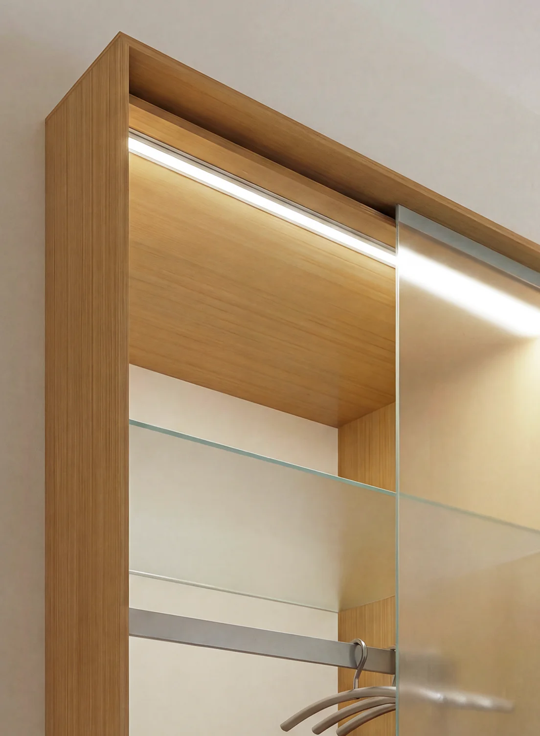 Modernes Schrankdesign in Holzoptik mit integrierter GERA Einbauleuchte abgewinkelt und Glasschiebetüren.