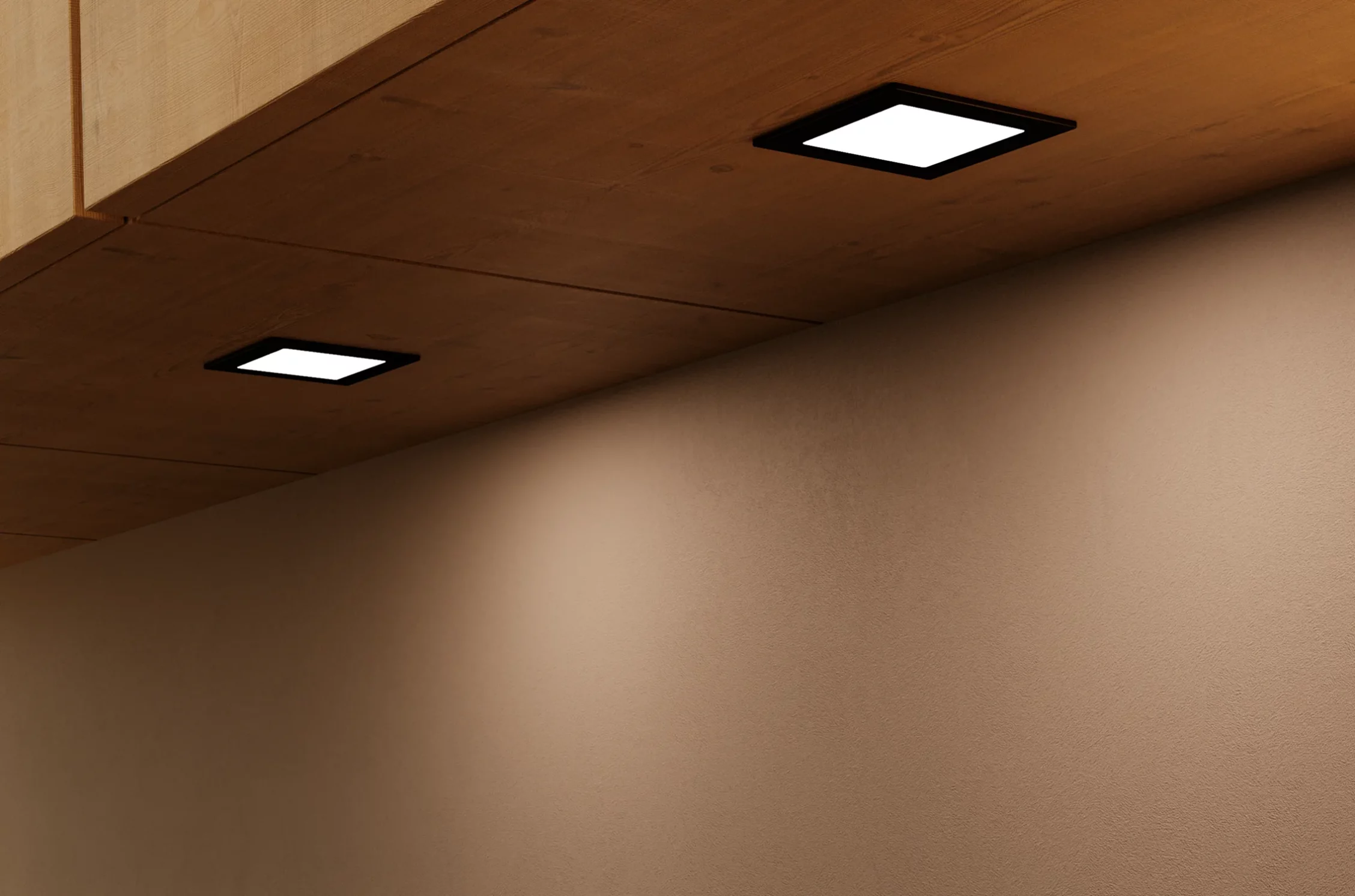 Nahaufnahme einer hölzernen Schrankunterseite mit zwei quadratischen GERA Einbauleuchten, die auf eine beigefarbene Wand darunter leuchten.