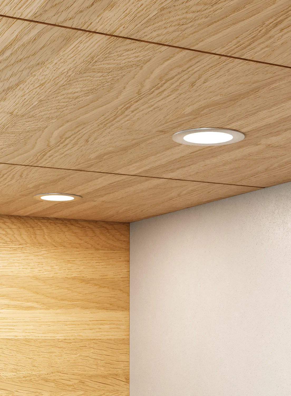 Nahaufnahme einer hölzernen Schrankunterseite mit zwei runden GERA Einbaustrahlern, die auf eine beigefarbene Wand darunter leuchten.