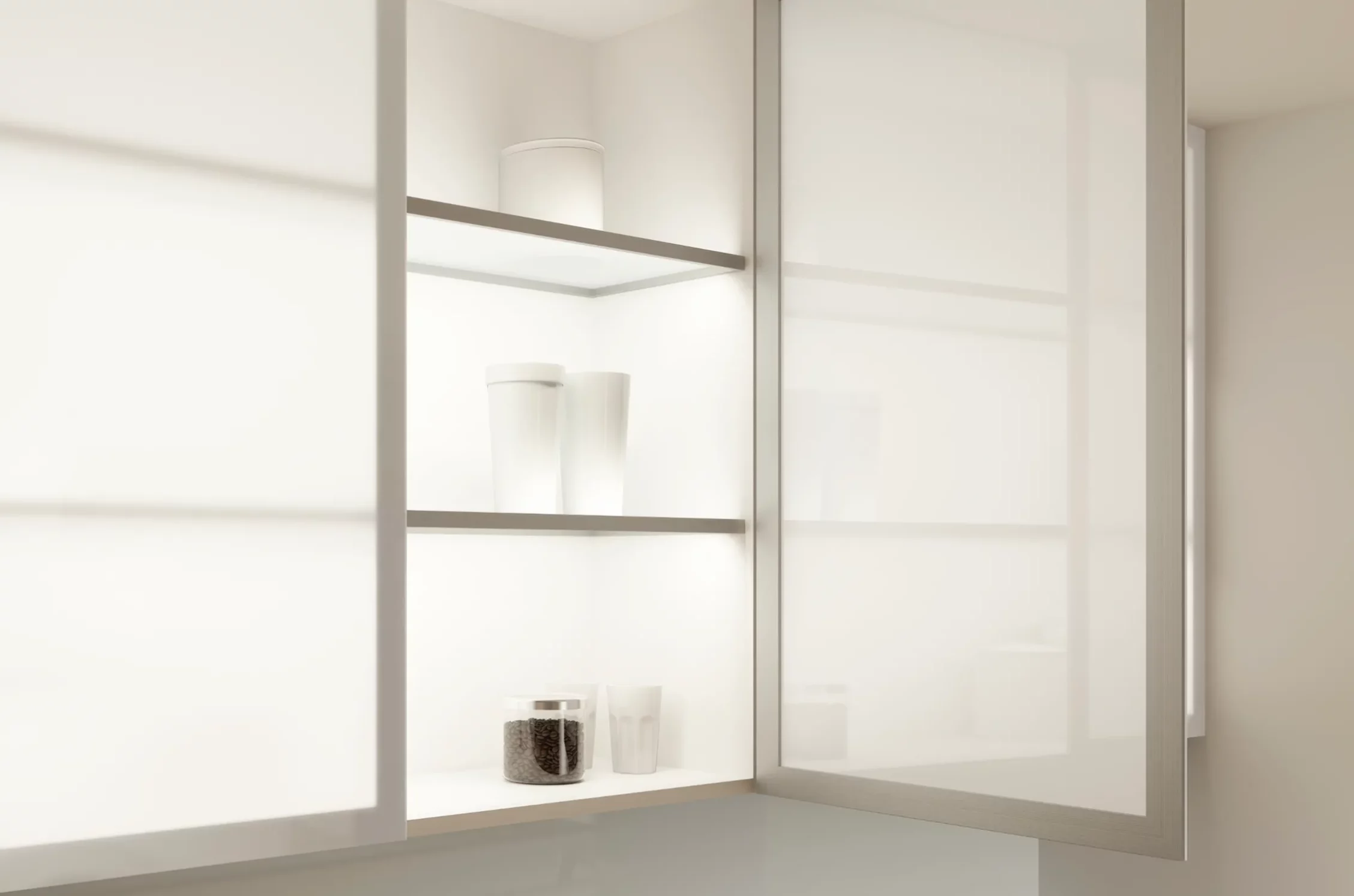 Beleuchtetes, minimalistischer Küchenschrank mit Glastüren. Gläser, Tassen und ein Glasbehälter gefüllt mit Kaffeebohnen stehen auf den GERA Einlegeböden.