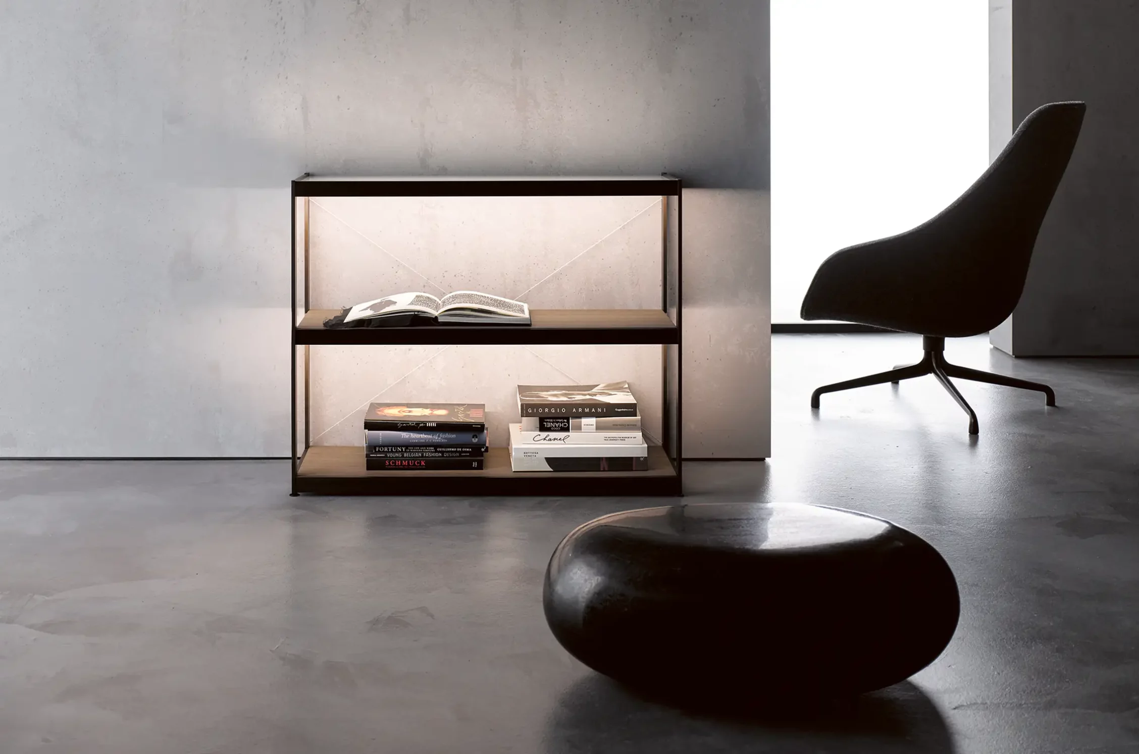 Minimalistisches Wohnzimmer mit beleuchtetem Sideboard GERA Item, schwarzem Sessel und abstraktem Gemälde, an der Wand lehnend.