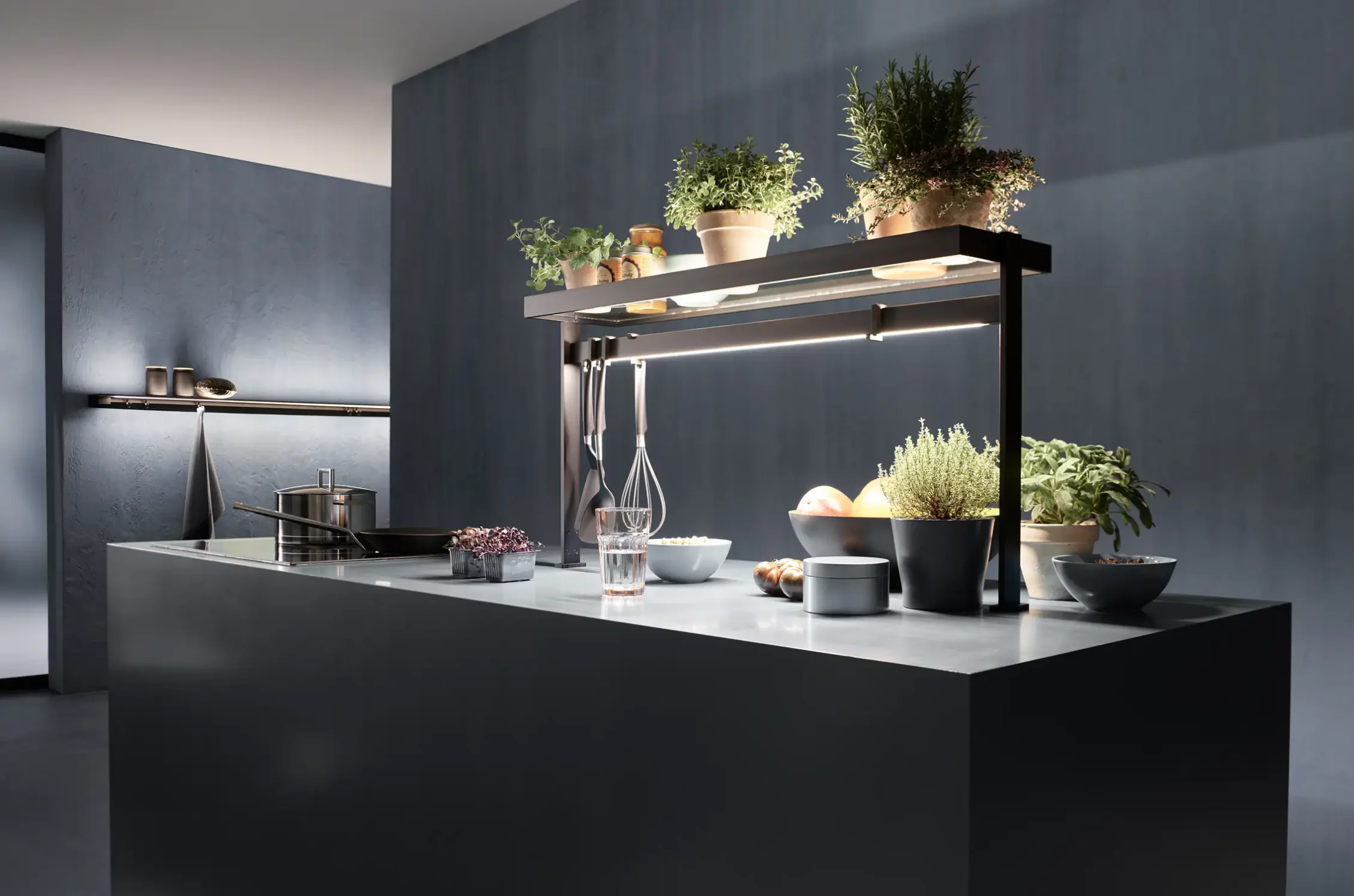 Moderne Kücheninsel mit Lichtbrücke GERA Lucina Up, Kochutensilien und frischem Gemüse.