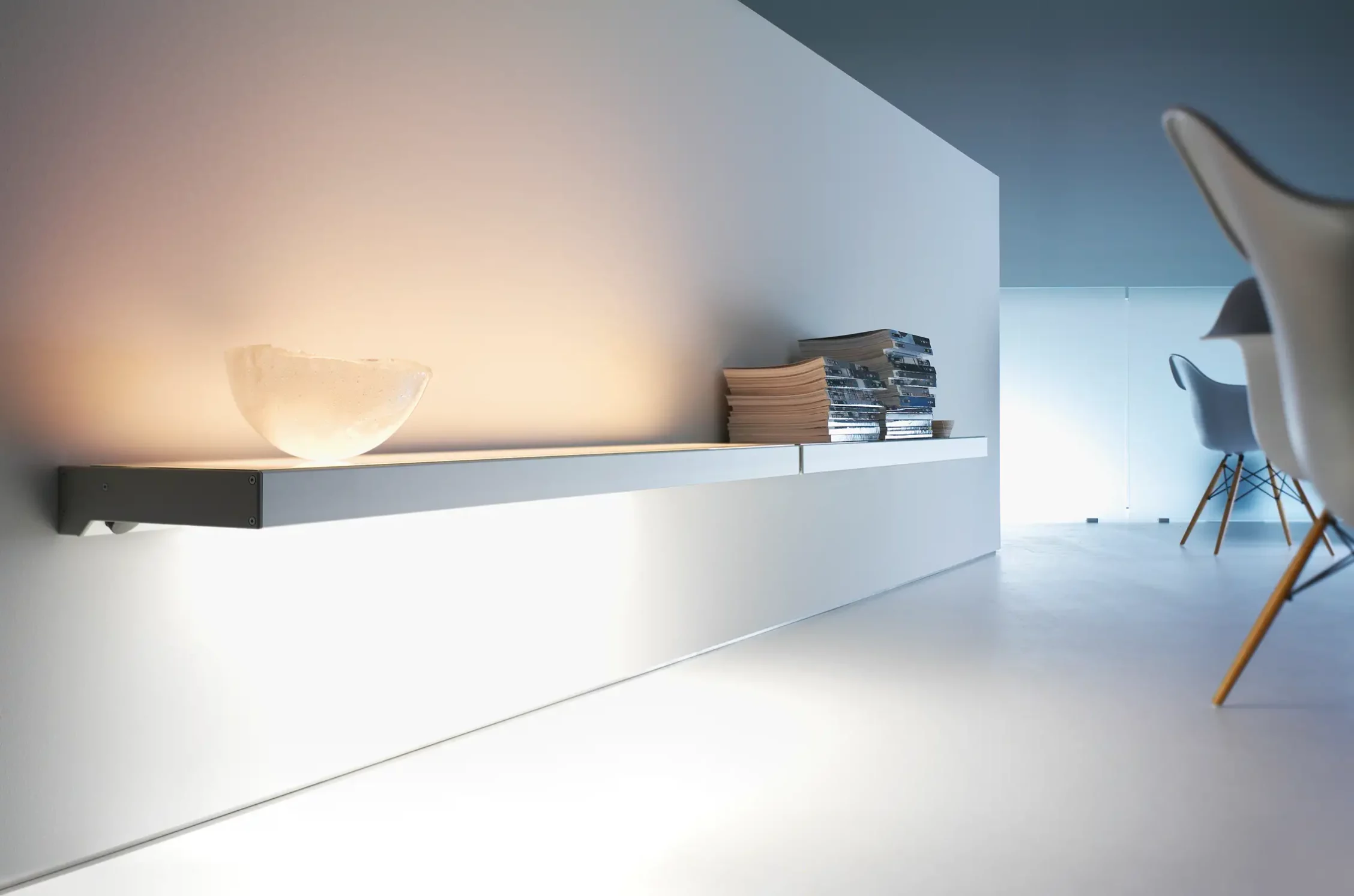 Lichtbord GERA One, darauf eine erleuchtete Schale und Bücherstapeln in einem minimalistisch gestalteten Raum.