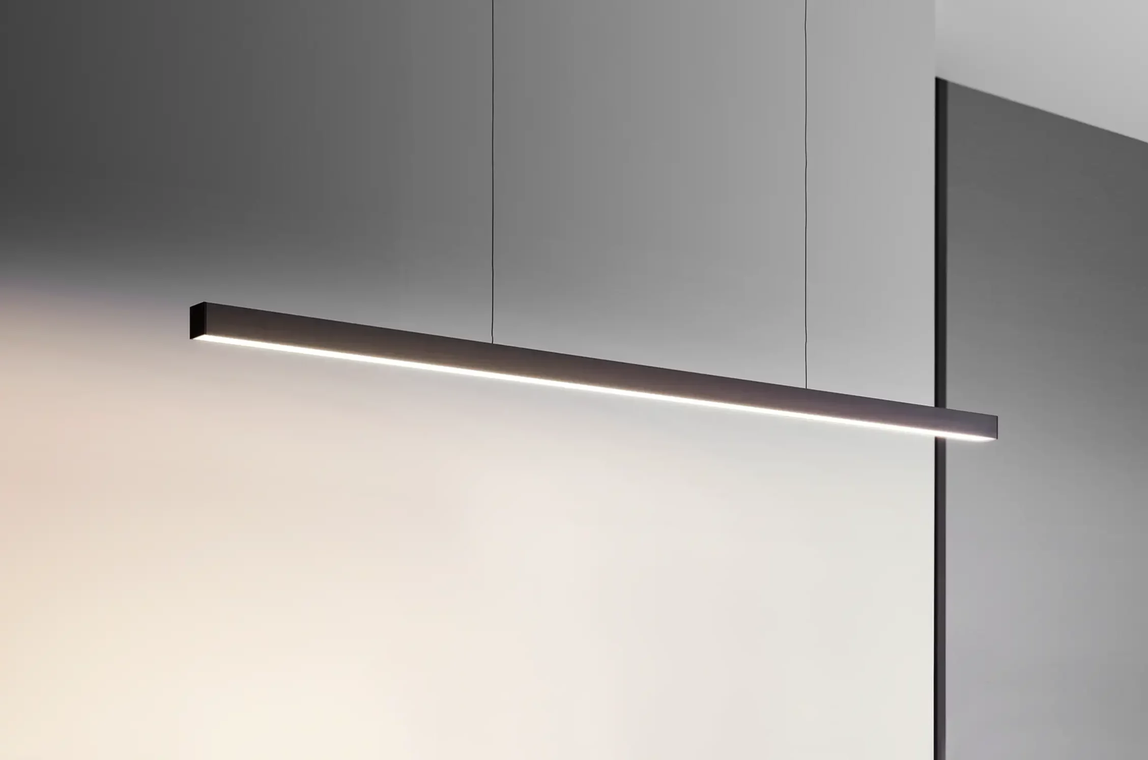 Schwarze Pendelleuchte GERA Quadra Swing in minimalistischem Raum.