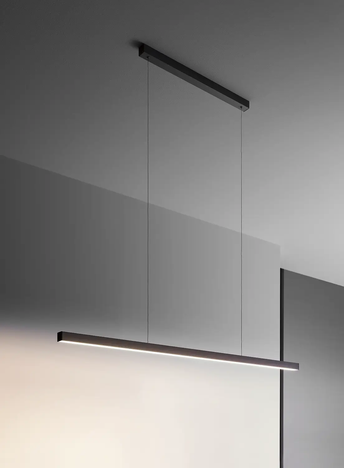 Schwarze Pendelleuchte GERA Quadra Swing in minimalistischem Raum.