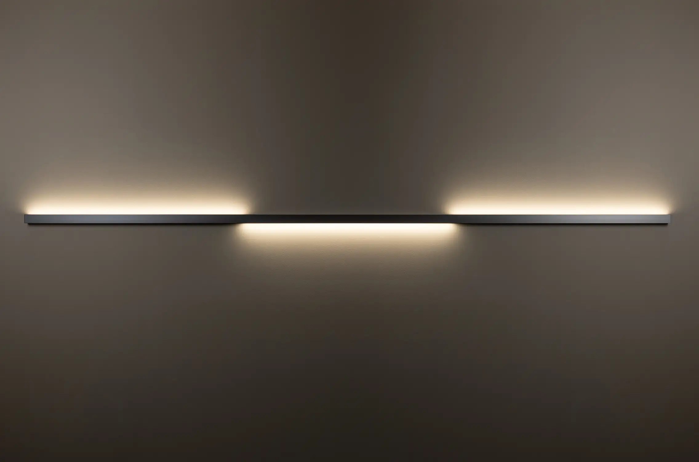 Horizontal installierte Wandleuchte GERA Quadra Wall wirft Licht nach oben und unten auf dunkle Wand.