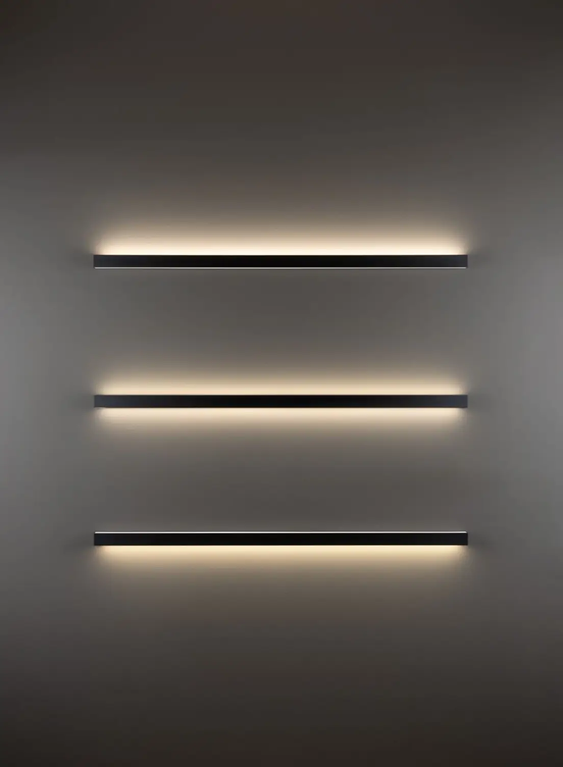 Drei horizontale, übereinander installierte beleuchtete GERA Quadra Wall Wandleuchten an einer dunkelgrauen Wand.