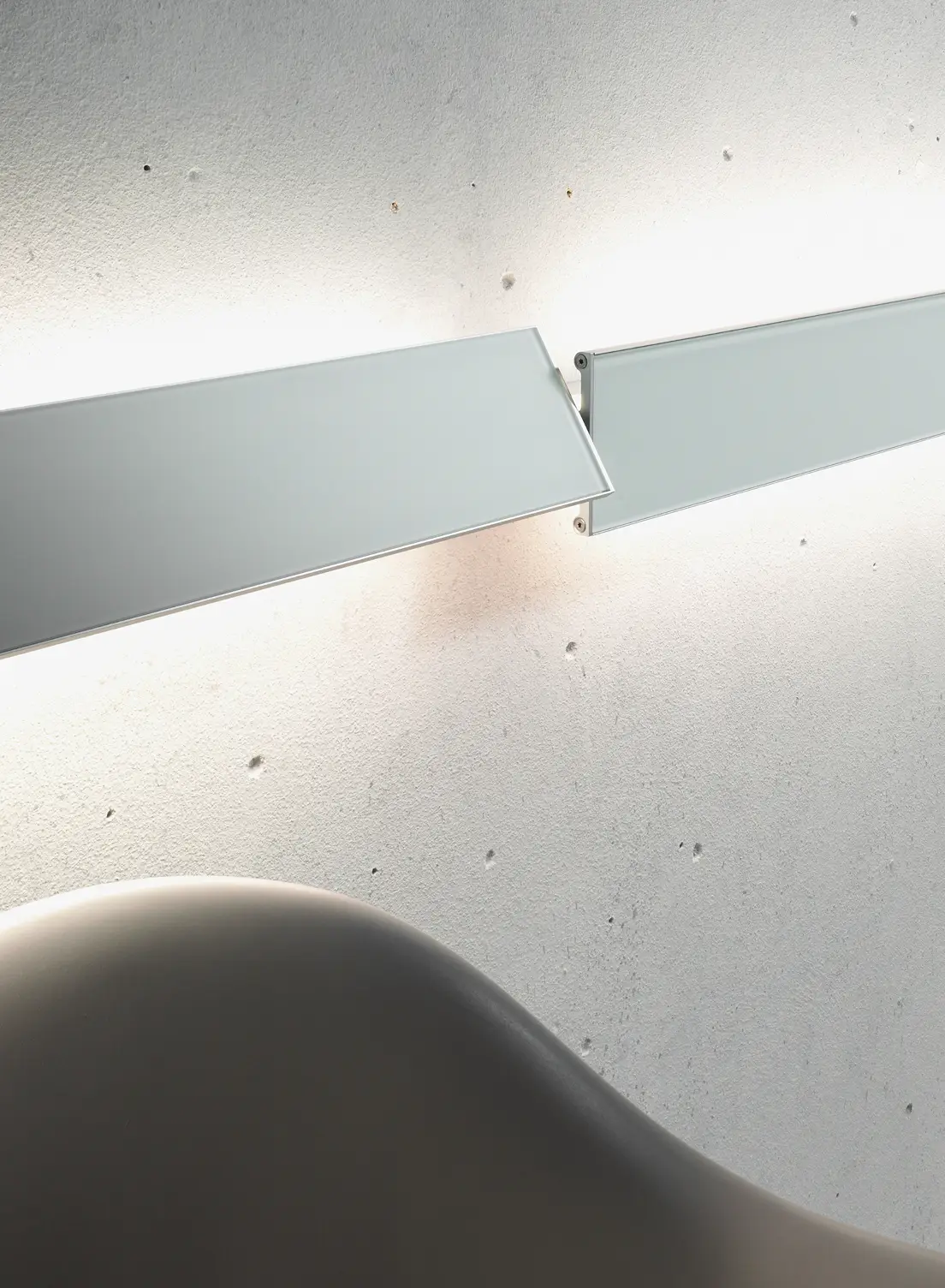 Zwei GERA Slant Leuchten mit unterschiedlicher Winkelung vor Sichtbetonwand.