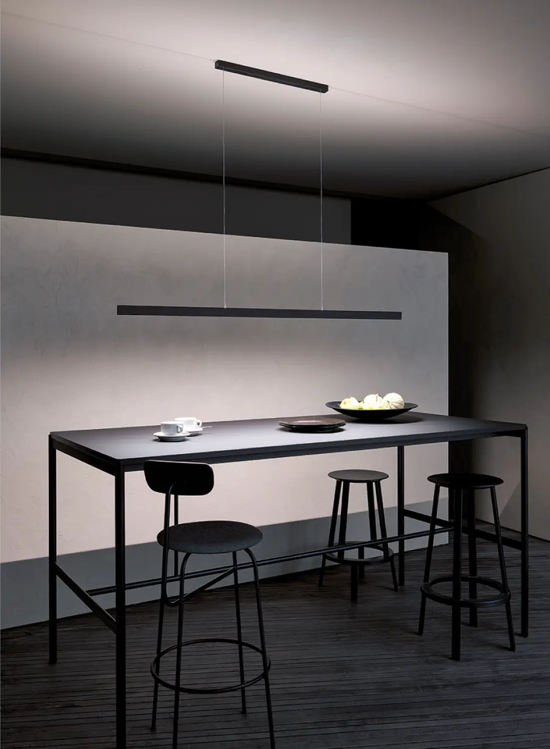 Moderner minimalistischer Esstisch mit schwarzen Barhockern beleuchtet von der Pendelleuchte GERA Solid.