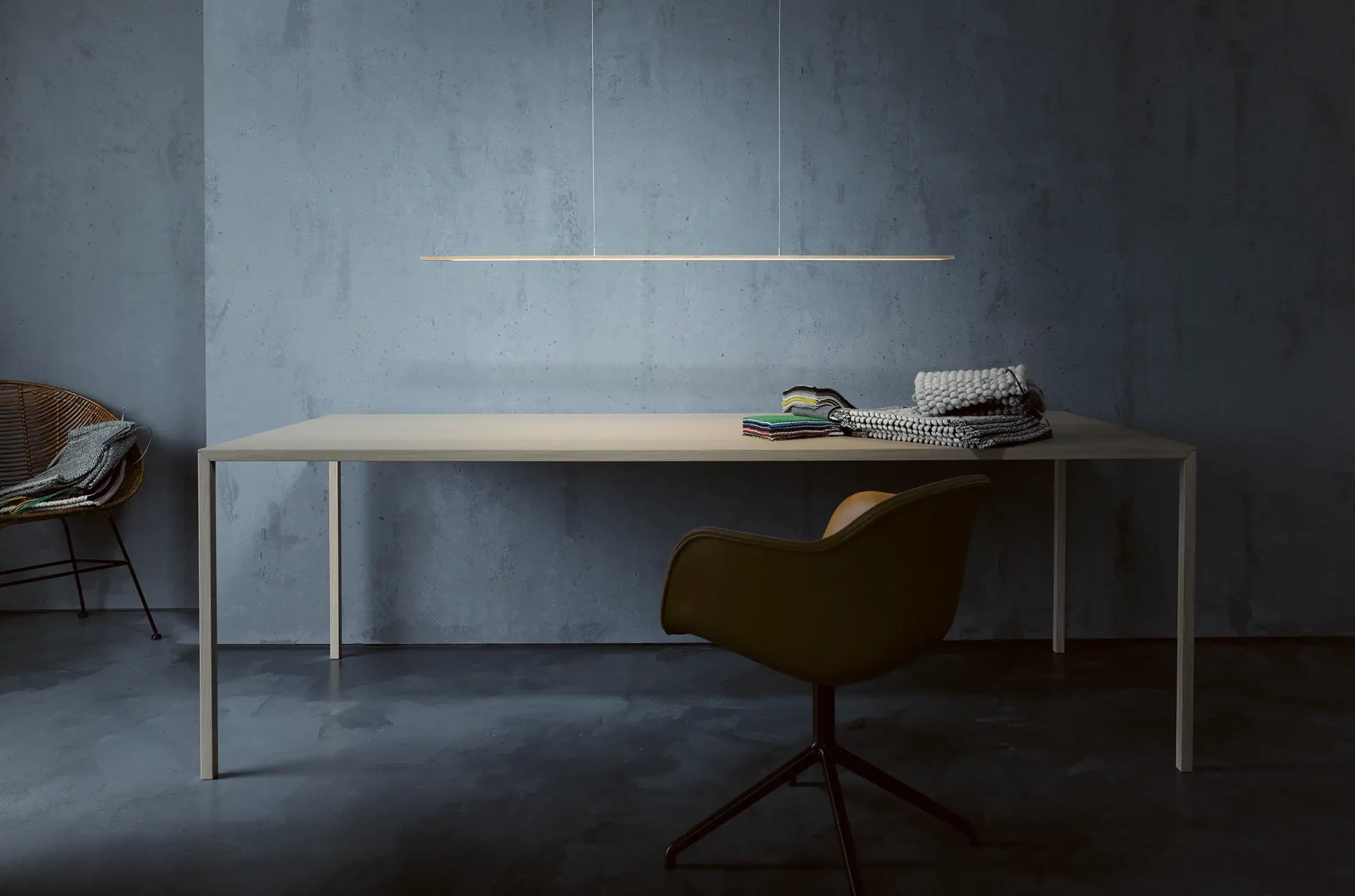 Pendelleuchte GERA Twig über einem hellen Holztisch vor einer grauen Betonwand.