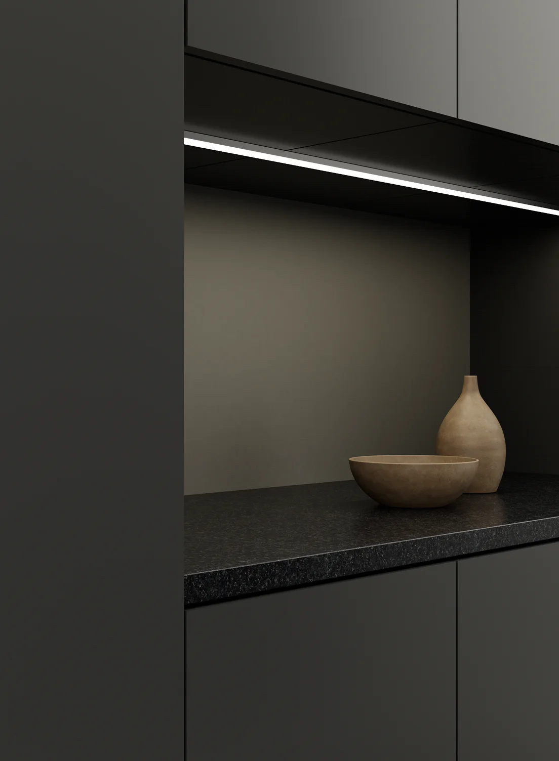 Gera Unterbauleuchte 32×10 montiert unter einem Küchenschrank, eine dunkle Granitarbeitsfläche mit Schale und Vase beleuchtend.